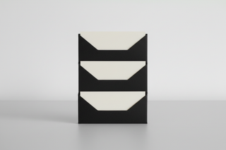 A quality control image without looking technical. Three identical off white cards stacked with perfect alignment, each in a matching matte black sleeve. The edges line up precisely. A subtle shadow gap between each stack shows repeatability. Minimal composition. Soft diffused light. No checklists, no numbers, no text.
